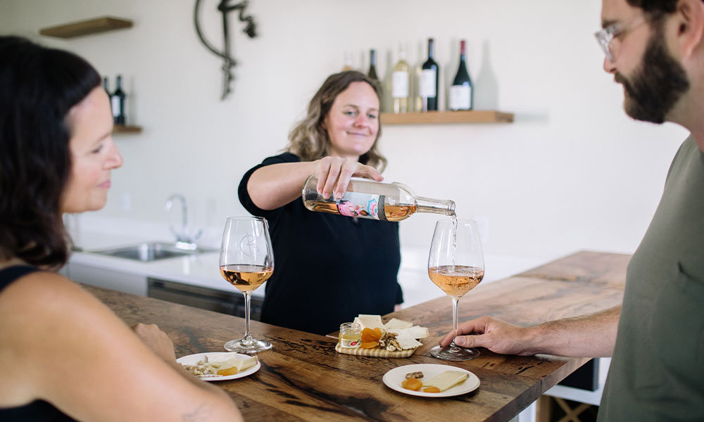 Jill pours a rose for two visitors at the Rincon Mountain tasting room